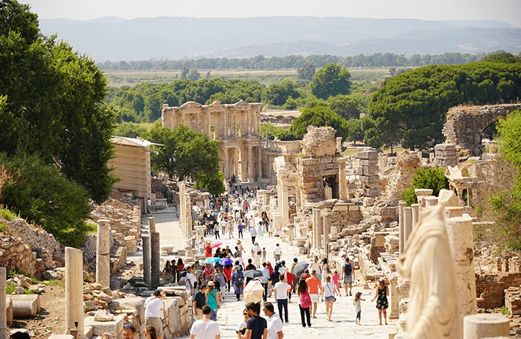 Visitors walking along the ancient marble streets of Ephesus