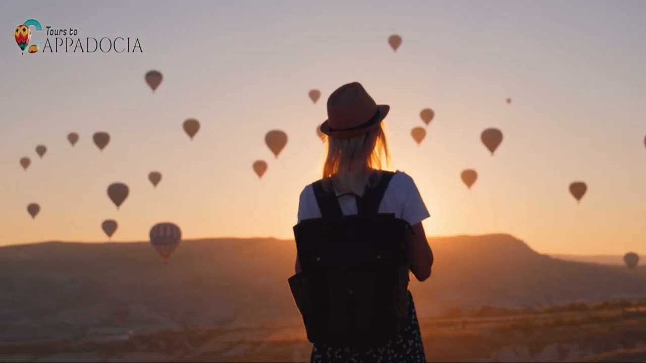 A traveler watching balloons in the morning sky
